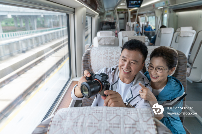 快乐的老年夫妇坐地铁用相机拍照