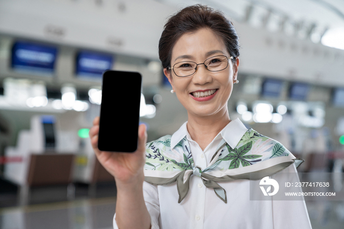 老年女人在机场展示手机