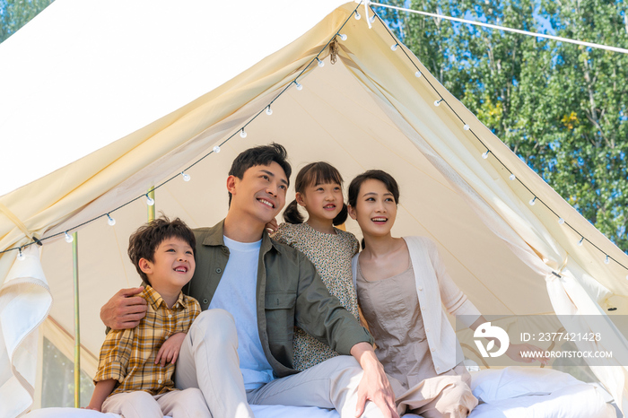 露营地帐篷下快乐的一家人