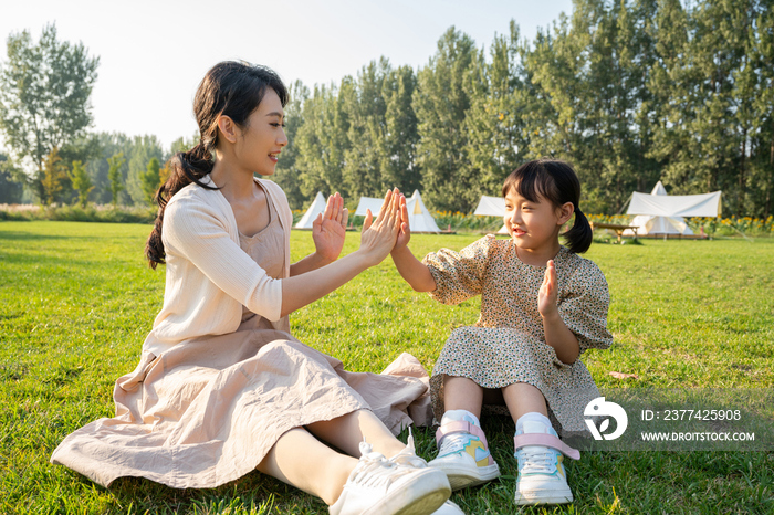 妈妈和女儿在草地上做游戏