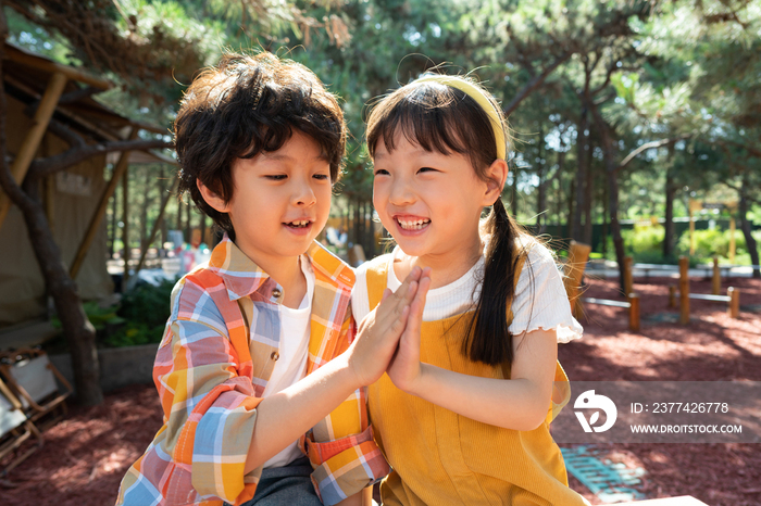 两个小孩子开心击掌庆祝