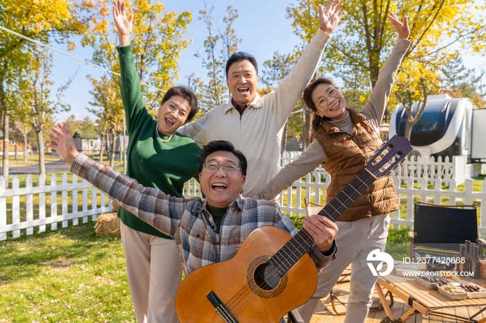 一群中老年人在房车露营地弹吉他唱歌