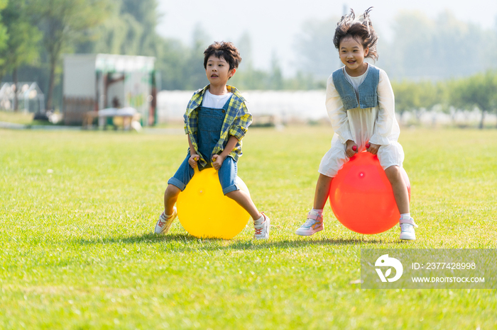 两个小孩在草地上做游戏