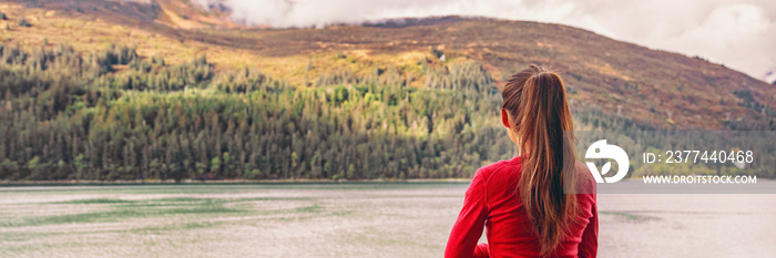 Woman tourist on Autumn travel holiday relaxing at fall foliage forest background in cozy woods cabin or cruise balcony outdoor resort. Banner panorama.