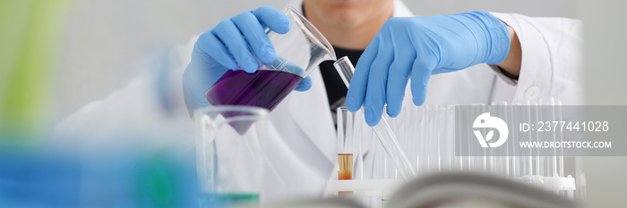 A male chemist holds test tube of glass