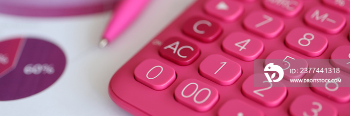 Pink calculator and pen lying on documents with graphs and diagrams closeup