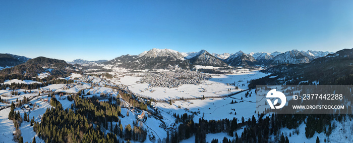 Aerial panoramic view of the snowy mountain village Oberstdorf with the mountain peaks in Bavarian Alps, Germany.