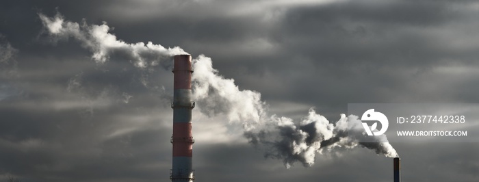 Panoramic view of the large central heating station in dramatic light. Pipe close-up. Ecology, ecological issues, fuel and power generation, environmental damage. Dark industrial cityscape