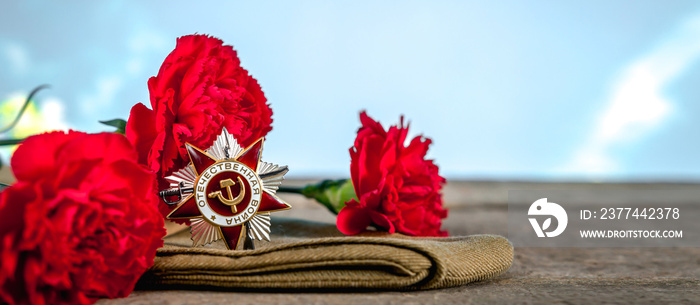 May 9, Victory Day holiday. Holiday card with order, St. George ribbon, flowers and military cap. May 9 background, copy space and translation with Victory Day.