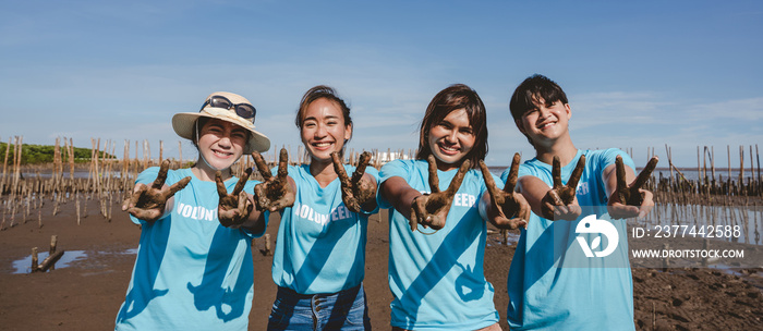 A Volunteer group of people are smiling and showing hands in the park.,The volunteering concept does not destroy the environment.