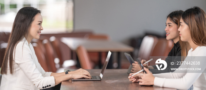 Young Asian college students have meetings with a teacher advisor or a tutor to discuss the project