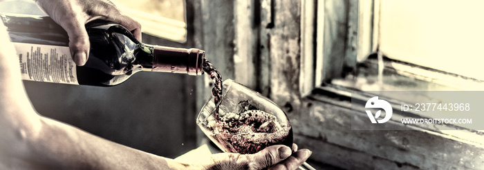 toned. Pouring wine on a old background