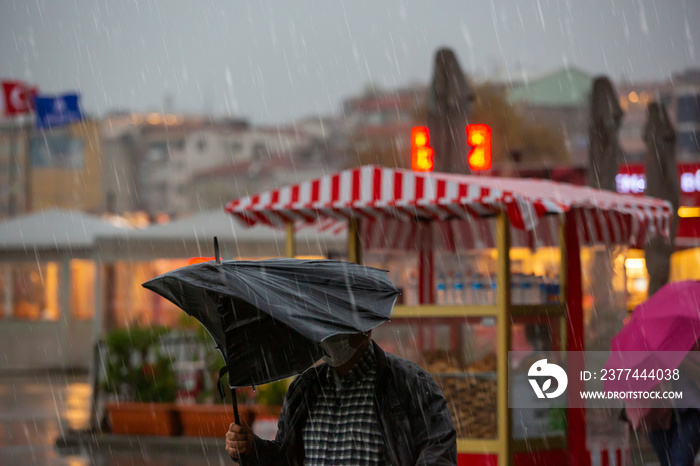 Man with a broken umbrella on a rainy day