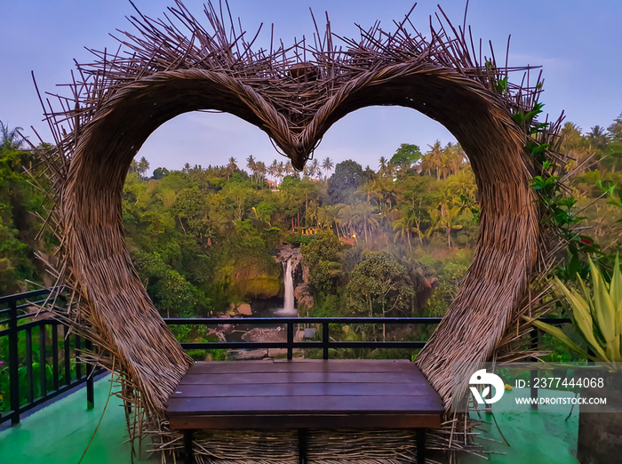 Love shaped sit for couple tourist in bali with the Tegenungan waterfall in the background in Indonesia