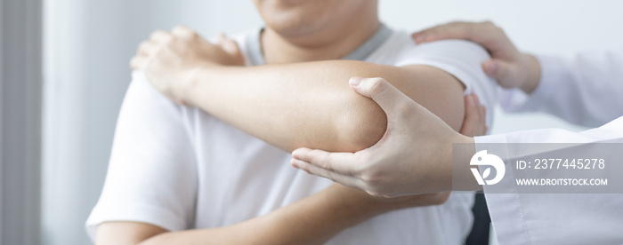 Physical therapy, Female physiotherapist treats arms and shoulders pain for a male patient attending in clinic, Bone arrangement, Non-surgical medical treatment, Modern medical techniques.