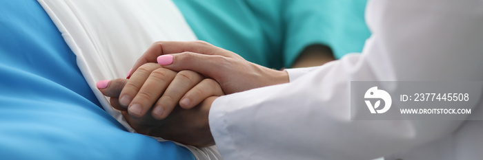 Female doctor hands hold male arm in medical hospital closeup. Medicine work drama concept