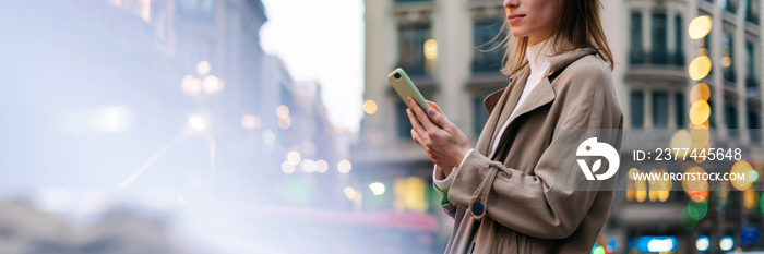 Young woman with smartphone on night street