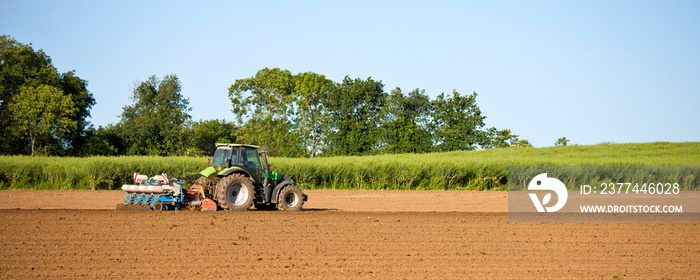 Tracteur au champ en train de labourer la terre au printemps.