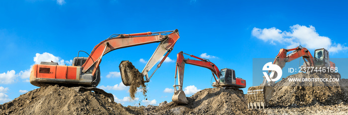 Three excavators working at building site on sunny day