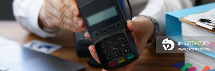 Man holding modern credit card reader machine for cashless payment