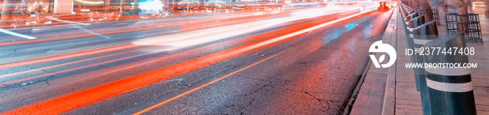 Car light trails at night on a main city avenue