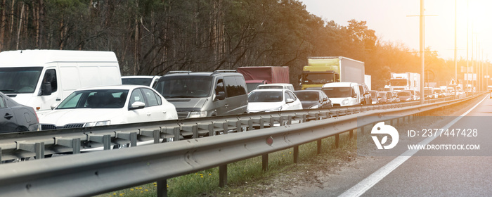 Highway interstate road with car traffic jam and tree forest on background. Motorway bumber barrier gridlock due country border control point. Vehicle crash accident and queue bottleneck on freeway