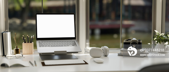 Modern creative office desk workspace with notebook laptop on a laptop stand. close-up image.