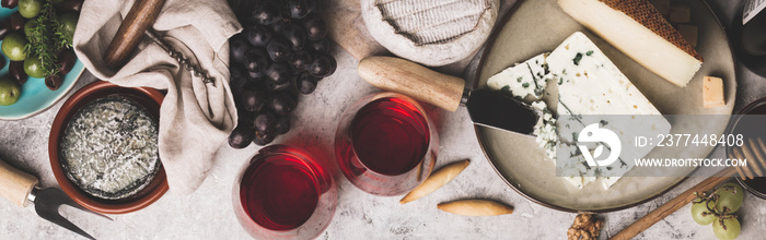 Red wine with charcuterie assortment on rustic concrete background