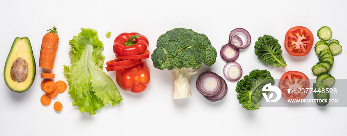 Creative layout made of variety of vegetables for making salads. Carrots, lettuce, kale, tomato, cucumber, broccoli, avocado, red bell pepper, onion.  White background, top view, copy space baner size