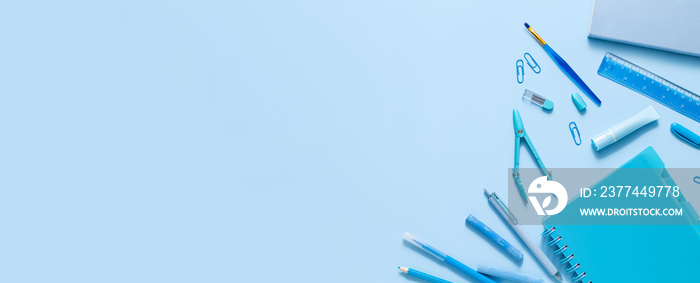 Top view of various stationery on blue pastel background. Back to school concept banner with place for text. Monochrome color