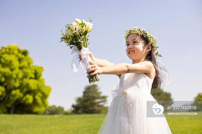 可爱的婚礼花童拿着捧花