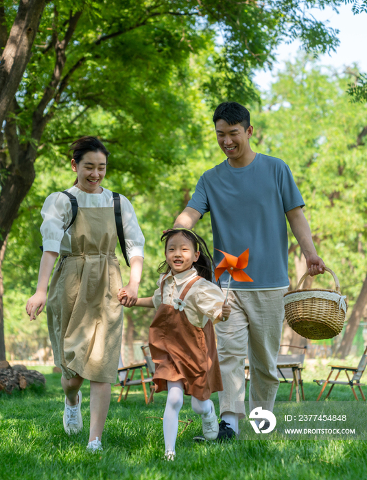 一家四口露营在草地上开心奔跑