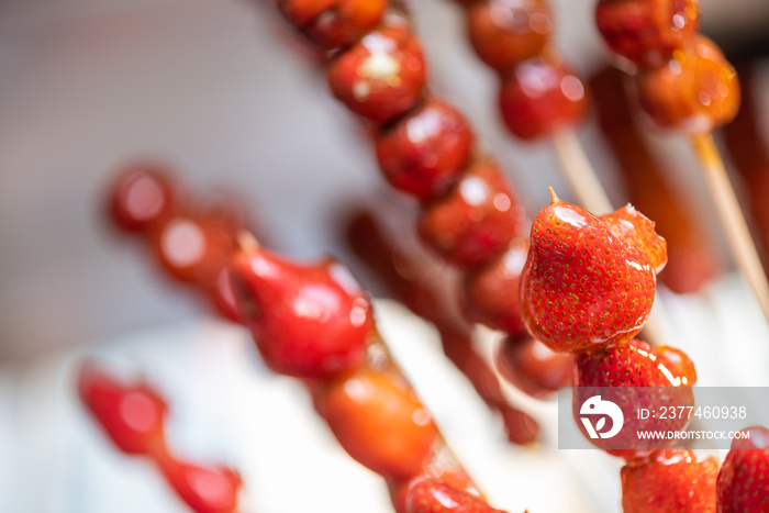 Tanghulu traditional Chinese hard caramel coated strawberry skewers close-up also called bing tanghulu candied hawthorn sticks