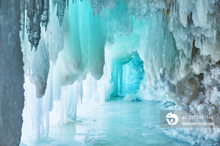 Narrow blue cave of ice in winter