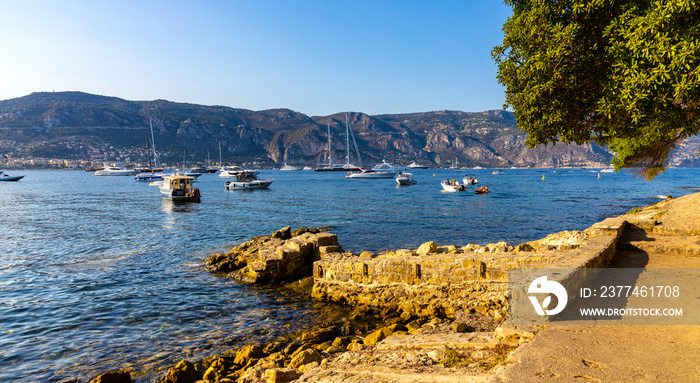 Rocky shoreline landscape of Saint-Jean-Cap-Ferrat resort town with sightseeing path on Cap Ferrat cape at French Riviera of Mediterranean Sea in France