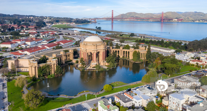 Palace of Fine Arts, San Francisco, California, aerial view with Golden Gate Bridge in the background. Morning light, copy space in sky. Palace reflection in water. Blue sky, red bridge.
