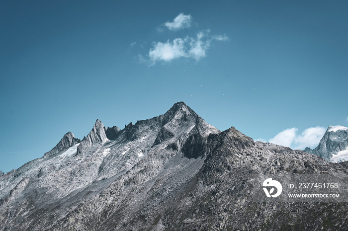 mountain peak with a single cloud and paragliders