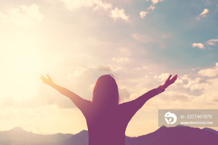 Copy space of woman rise hand up on top of mountain and sunset sky abstract background.