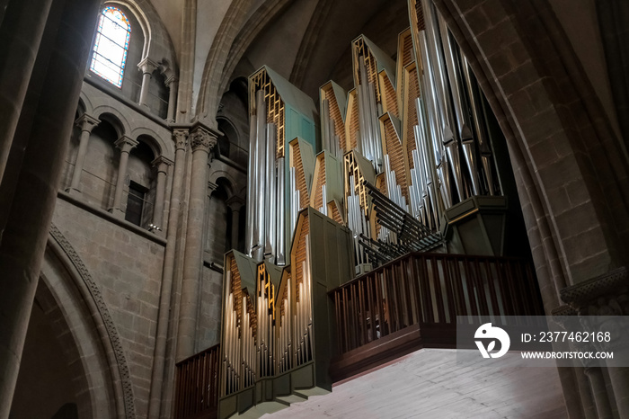 Pipe organ of Saint Peter’s Cathedral in Geneva, Switzerland, surrounded by beautiful stone arches.