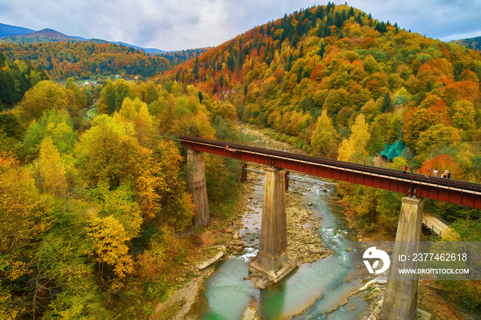 Aerial top view of a beautiful mountain village Yaremche in Carpathian mountains, Western Ukraine. Mountain river, houses and hotels, autumn forest, rocks.