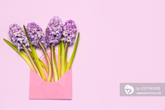 Envelope with beautiful hyacinth flowers on color background