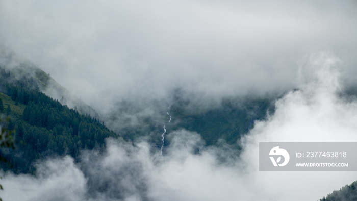 low hanging clouds in the mountains at a summer day