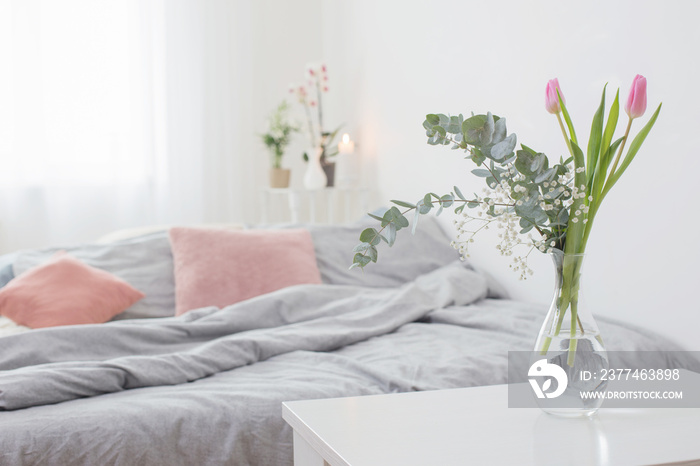 tulips in vase in cozy bedroom