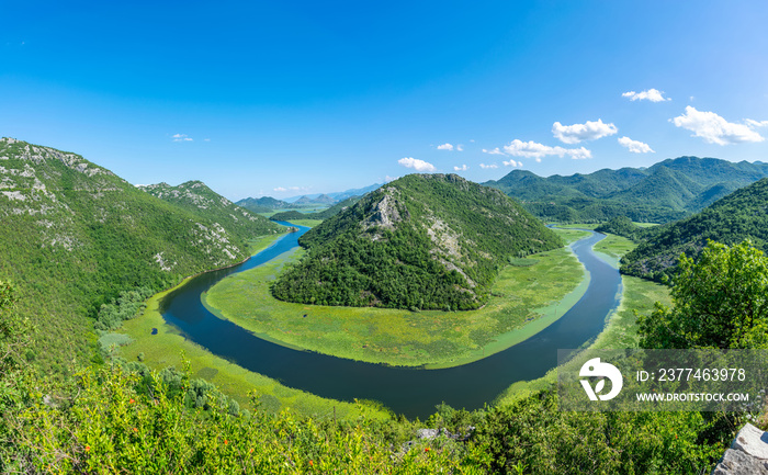 The picturesque meandering river flows among green mountains.