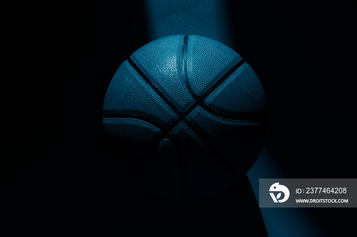 Basketball ball with natural lighting on blue background. Blue color filter. Sport team concept. Horizontal sport theme poster, greeting cards, headers, website and app