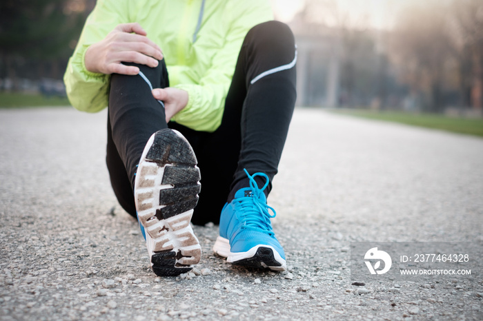 Runner with injured ankle while training in the city park in col