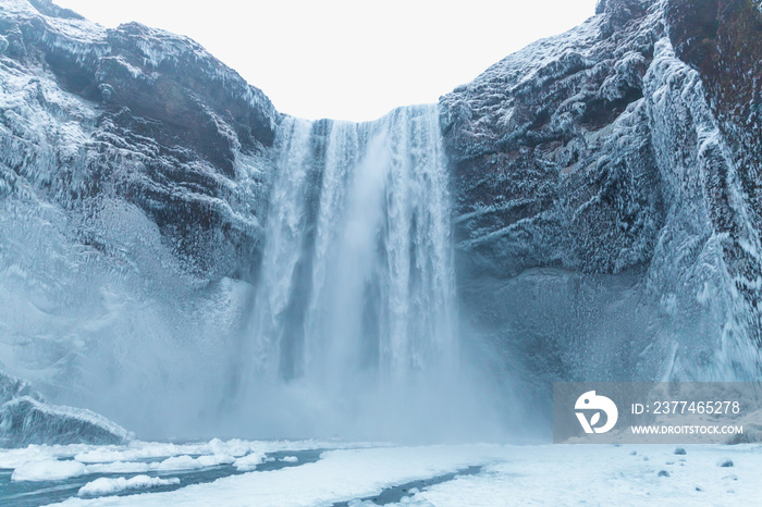 beautiful view of scenic Skgafoss waterfall and snow-covered rocks in iceland