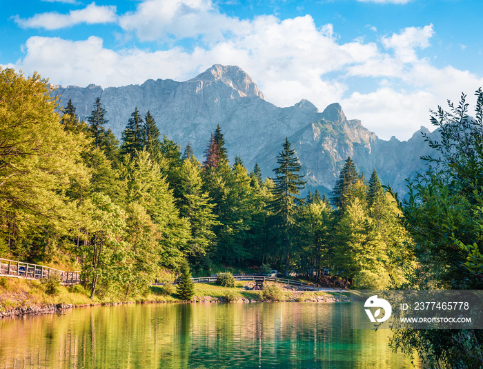 Sunny morning view of Fusine lake. Colorful summer scene of Julian Alps with Mangart peak on background, Province of Udine, Italy, Europe. Traveling concept background.