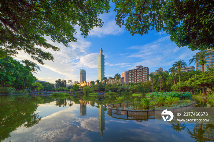 Taipei park garden and reflection of skyscrapers buildings. Financial district and business centers in smart urban city at noon, Taiwan.