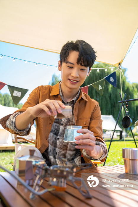 男孩坐天幕下煮咖啡